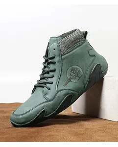 Detalle del botín Chelsea verde salvia con cuello de punto y emblema de logo de dragón