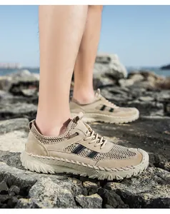 Detailopname van kaki ademende mesh herensneakers op rotsen tijdens buitenactiviteiten