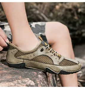 Macro side view of khaki leather mesh sneakers on outdoor rocks highlighting breathability