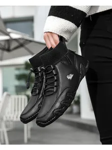 Detail der schwarzen High-Top Sneaker mit Strickkragen und Bergziegen Logo an der Seite