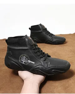 Detalle de bota Chelsea negra de cuero granulado con cuello de punto y logotipo