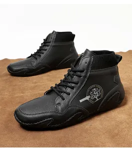 Vista detallada de botas Chelsea negras en cuero texturizado con cuello de punto elástico