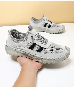 Detail van de handgestikte lederen zool en ademende mesh-stof op grijze herensneakers