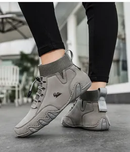 Nahaufnahme grauer Sock-Sneaker mit Widder-Logo und gewellter Gummisohle am Fuß