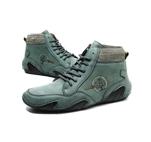 Detalle de botines Chelsea de ante verde azulado con cuello de punto gris y logo