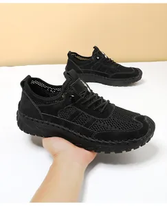Detail van zwart ademend mesh en runderleer stiksels op heren sportschoenen