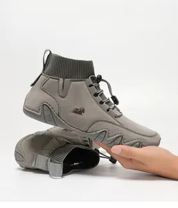 Detail von grauem Outdoor-Schuh mit Strickmanschette und elastischem Schnürsystem für Herren