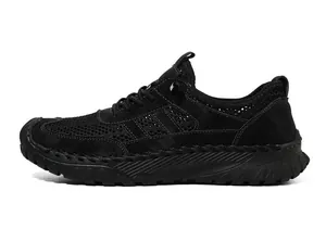 Detailweergave van zwarte mesh en suède sneakers met antislip rubberen zool en stiksels