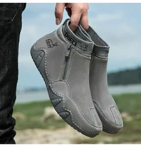 Détail de bottines en cuir gris avec fermeture éclair latérale et semelle en caoutchouc