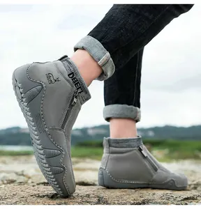 Détail de bottines grises en cuir avec fermeture éclair latérale et semelle en caoutchouc