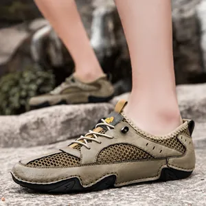 Men's khaki breathable leather mesh hiking shoes with durable rubber soles on rock