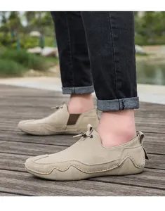Primer plano de mocasines de ante caqui con costuras exteriores y suela de goma ondulada