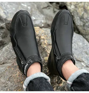 Détail de bottines en cuir pour hommes avec zip latéral et col en maille sur rochers