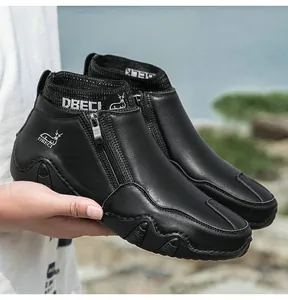 Détail d'une botte en cuir noir avec fermeture éclair en métal et col élastique