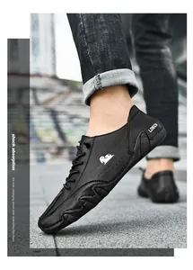 Detailopname van zwarte leren herenschoenen met LDECK-logo in een stedelijke omgeving