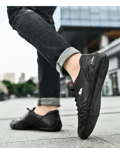 Detailopname van zwarte leren vrijetijdsschoenen voor heren met LDECK-logo en antislipzool