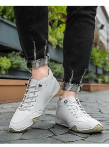 Λήψη macro λευκά ψηλά δερμάτινα sneakers με καφέ λαστιχένια σόλα σε πέτρινο δρόμο