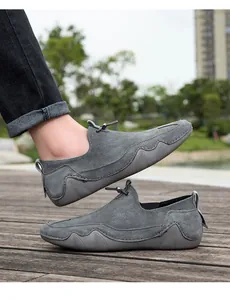 Primer plano de mocasines de ante gris con suelas de goma onduladas para exteriores