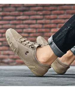 Close-up of khaki suede moccasin featuring a rubber wave sole and fox logo on brick background