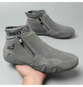Détail de bottines en cuir gris avec fermeture éclair, col en tricot et logo de marque
