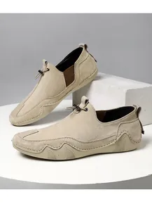 Detalle de mocasines de ante beige con paneles elásticos laterales y suela de caucho