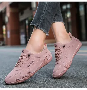 Outdoor street view of pink suede casual sneakers for women featuring wave stitching detail