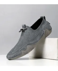 Detalle de mocasín de ante gris con cordones elásticos y suela de goma ondulada