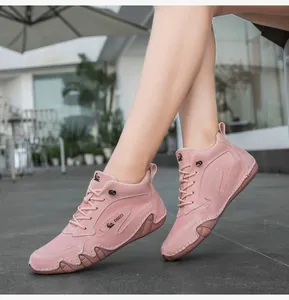 Detail of pink suede high-top sneakers showing wavy rubber sole and lace-up design