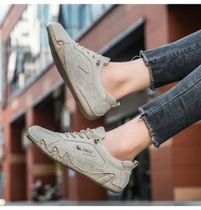 Macro detail of khaki suede outdoor shoes featuring refined stitching and grippy rubber soles