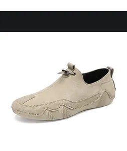 Detalle de mocasines de ante beige con cordón metálico y suela de goma ondulada única