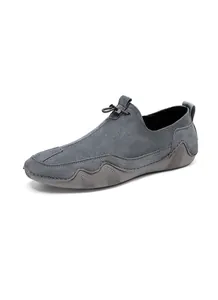 Detalle macro de mocasines de ante gris para hombre con cordón y suela con textura de onda