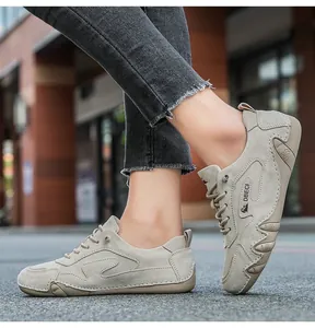 Side view of beige suede outdoor sneakers with rubber soles on a street setting