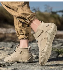 Detail von Khaki Wildleder High-Top-Stiefeln mit Gummisohle auf felsigem Gelände