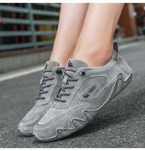 On-foot view of grey suede leather loafers with wave-edged soles on asphalt background