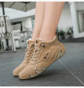 Close-up of light brown high-top leather boots featuring decorative logo and lace-up design
