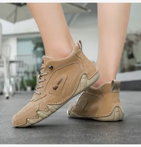 Detail of khaki suede high-top outdoor boots with reinforced stitching and rubber sole