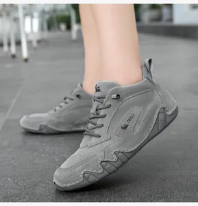Detail of grey leather boots with DBECI logo and rugged rubber sole in outdoor setting