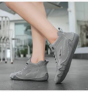 Macro detail of OBECI gray suede high-top sneakers showing handmade stitching and heel pull tab