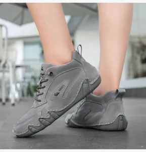 Detail of grey suede high-top boots with visible hand-stitching and rubber sole