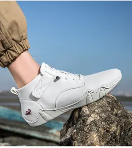 Outdoor-Lederstiefel in Weiß mit Klettverschluss und Widder-Logo auf felsigem Untergrund