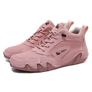 Close-up of pink high-top leather boots featuring hand-stitched toe and durable rubber sole