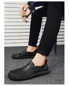 Detailed view of black leather loafers featuring bold hand-stitched seams and rubber soles