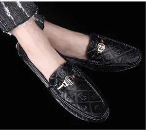 Κοντινό πλάνο μαύρων δερμάτινων loafers με καπιτονέ υφή και χρυσή μεταλλική αγκράφα