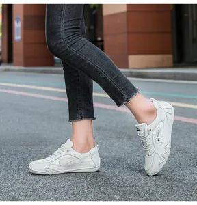 Detail view of white leather leisure sneaker with DBECK logo on dynamic outdoor path