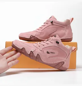 Detail of pink genuine leather high-top boots with logo and artisan stitching details