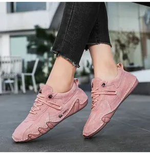 Outdoor shot of pink suede casual sneakers with white stitching and durable rubber soles
