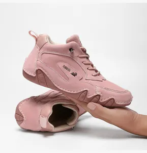 Detailed side view of pink high-top leather sneakers with textured rubber non-slip soles