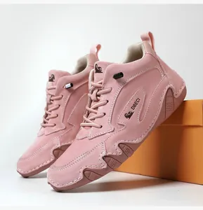 Detailed macro view of pink suede high-top sneakers with white contrast stitching and logo