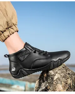 Detailansicht schwarzer Leder-Outdoorstiefel mit Ziegen-Logo auf Felsenhintergrund
