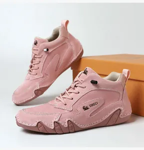 Detailed close-up of pink suede high-top boots with DBECI logo and hand-stitched rubber soles